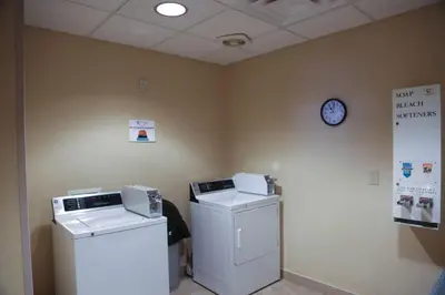 a room with two washing machines and a clock on the wall at Hampton Inn Morehead in Morehead