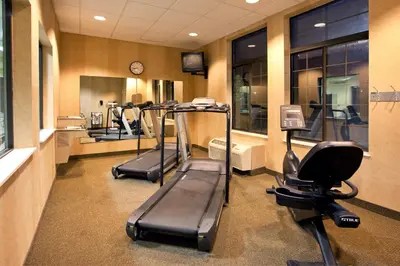 a gym with several treadmills and machines in a room at Holiday Inn Express Hocking Hills-Logan by IHG in Logan