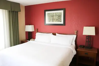 a bedroom with a white bed and red walls at Holiday Inn Express Hocking Hills-Logan by IHG in Logan