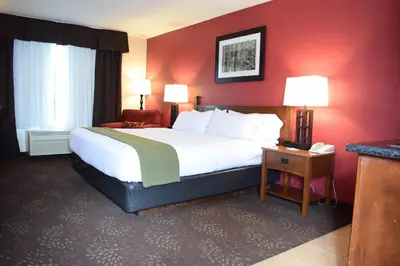 a hotel room with a large bed and red walls at Holiday Inn Express Hocking Hills-Logan by IHG in Logan