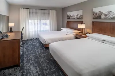 a hotel room with two beds and a desk at Delta Hotels by Marriott Huntington Mall in Barboursville