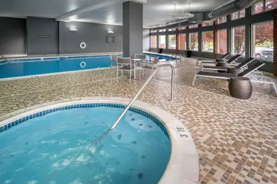 a large swimming pool with blue water in a building at Delta Hotels by Marriott Huntington Mall in Barboursville