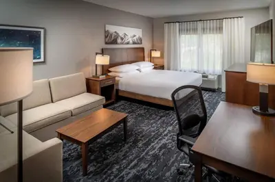 a hotel room with a bed and a couch at Delta Hotels by Marriott Huntington Mall in Barboursville