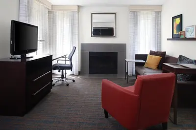 a living room with a red chair and a tv at Residence Inn by Marriott Cleveland Independence in Independence