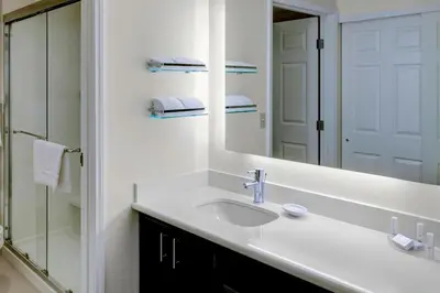 a white bathroom with a sink and a mirror at Residence Inn by Marriott Cleveland Independence in Independence