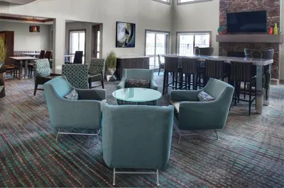 a lobby with chairs and tables and a bar at Residence Inn by Marriott Cleveland Independence in Independence