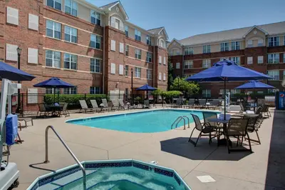 a pool at a hotel with chairs and tables and umbrellas at Residence Inn by Marriott Cleveland Beachwood in Beachwood