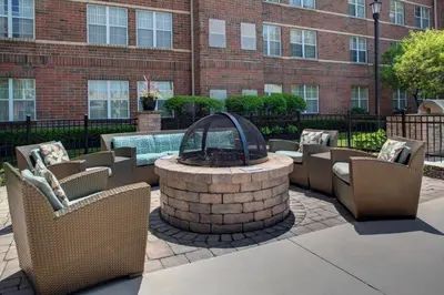 a patio with a fountain and chairs and a building at Residence Inn by Marriott Cleveland Beachwood in Beachwood