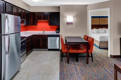 a kitchen with a table and a room with a bed at Residence Inn by Marriott Cleveland Mentor in Mentor