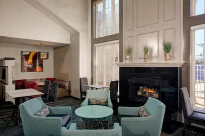 a lobby with a fireplace and chairs and a table at Residence Inn by Marriott Cleveland Mentor in Mentor