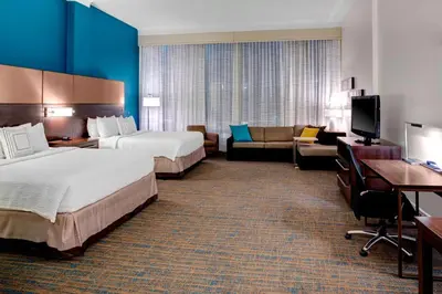 a hotel room with two beds and a couch at Residence Inn by Marriott Cleveland Downtown in Cleveland