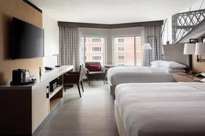 a hotel room with two beds and a television at Cincinnati Marriott at RiverCenter in Covington