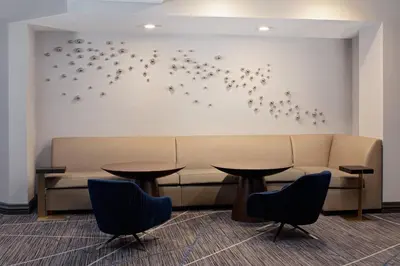 a waiting room with tables and a couch and birds on the wall at Cincinnati Marriott at RiverCenter in Covington