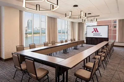 a conference room with a long table and chairs and a screen at Cincinnati Marriott at RiverCenter in Covington