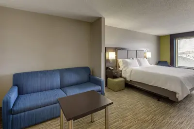 a hotel room with a bed and a couch at Holiday Inn Express Hotel & Suites Bryan-Montpelier by IHG in Holiday City