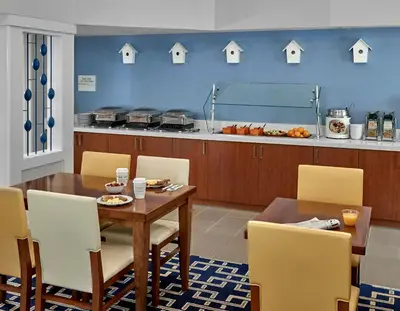 a dining room with a table and yellow chairs at Sonesta Simply Suites Cleveland Westlake in Westlake