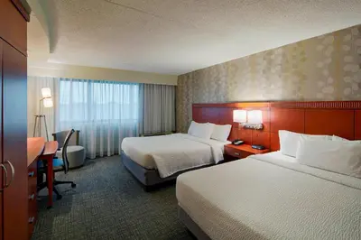 a hotel room with two beds and a desk at Courtyard by Marriott Columbus West/Hilliard in Columbus