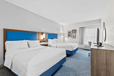 a hotel room with two beds and a television at Hampton Inn Akron-Fairlawn in Montrose
