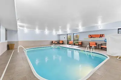 a pool in a hotel room with chairs and tables at Hampton Inn Akron-Fairlawn in Montrose