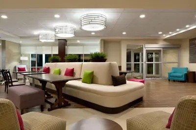 a lobby with a couch and a table and chairs at Home2 Suites by Hilton Cincinnati Liberty Township in Wetherington