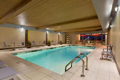 a large pool in a hotel with chairs and tables at Home2 Suites by Hilton Cincinnati Liberty Township in Wetherington