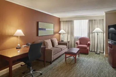 a hotel room with a couch and a desk and chair at DoubleTree by Hilton Akron Fairlawn in Fairlawn