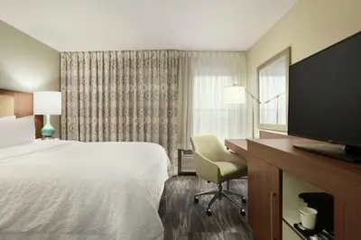 a hotel room with a bed and a desk and a television at Hampton Inn Findlay in Findlay