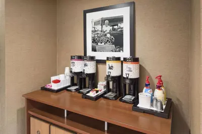 a hotel room with a counter with bottles of coffee at Hampton Inn Findlay in Findlay