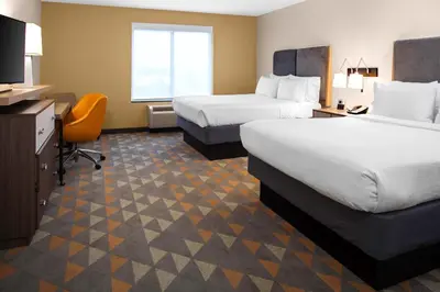 a hotel room with two beds and a desk at Holiday Inn Hotel & Suites Lima by IHG in Lima