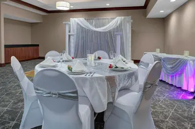a room with a table with white chairs and a curtain at Holiday Inn Hotel & Suites Lima by IHG in Lima