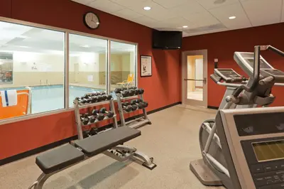 a fitness room with a gym with a swimming pool at Holiday Inn Hotel & Suites Lima by IHG in Lima