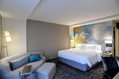 a hotel room with a large bed and a couch at Courtyard by Marriott Columbus OSU in Columbus