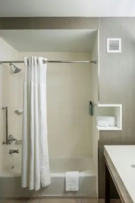 a bathroom with a tub and a shower curtain at Courtyard by Marriott Columbus OSU in Columbus