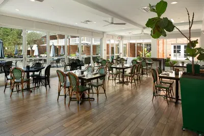 a dining room with tables and chairs and windows at Ohio University Inn and Conference Center in Athens