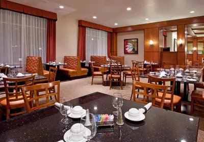 a dining room with tables and chairs in a restaurant at Holiday Inn Purdue - Fort Wayne by IHG in Fort Wayne