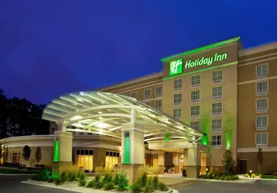 a hotel exterior at night with a building at Holiday Inn Purdue - Fort Wayne by IHG in Fort Wayne