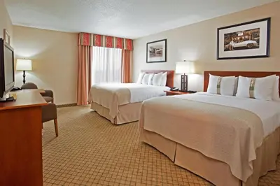 a hotel room with two beds and a flat screen tv at Holiday Inn Purdue - Fort Wayne by IHG in Fort Wayne
