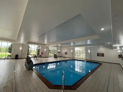 a large swimming pool in a building with a large ceiling at Holiday Inn Purdue - Fort Wayne by IHG in Fort Wayne