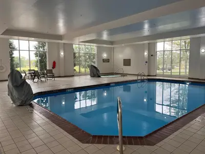 a large pool with blue water in a building at Holiday Inn Purdue - Fort Wayne by IHG in Fort Wayne