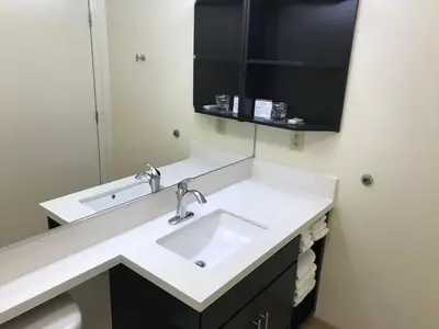 a bathroom with a sink and a mirror at Candlewood Suites Fort Wayne - NW by IHG in Fort Wayne