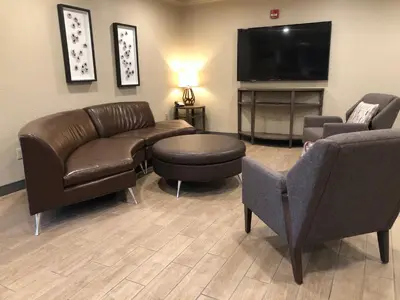 a waiting room with couches and a flat screen tv at Candlewood Suites Fort Wayne - NW by IHG in Fort Wayne
