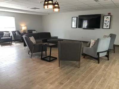 a waiting room with couches and chairs and a flat screen tv at Candlewood Suites Fort Wayne - NW by IHG in Fort Wayne