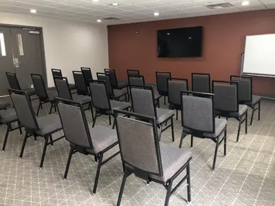 a room with a bunch of chairs in front of a screen at Candlewood Suites Fort Wayne - NW by IHG in Fort Wayne