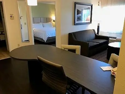 a hotel room with a table and a bed at Candlewood Suites Fort Wayne - NW by IHG in Fort Wayne