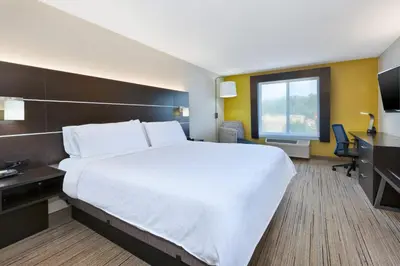 a hotel room with a large bed and a desk at Holiday Inn Express Hotel & Suites Cleveland-Richfield by IHG in Brecksville