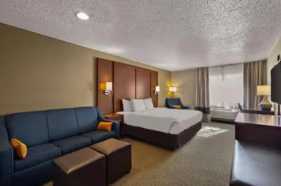 a hotel room with a bed and a couch at Comfort Inn Near Ouabache State Park in Bluffton