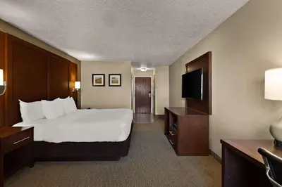 a hotel room with a bed and a flat screen tv at Comfort Inn Near Ouabache State Park in Bluffton
