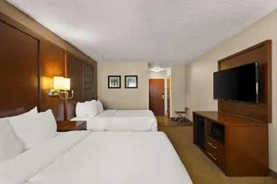 a hotel room with two beds and a flat screen tv at Comfort Inn Near Ouabache State Park in Bluffton