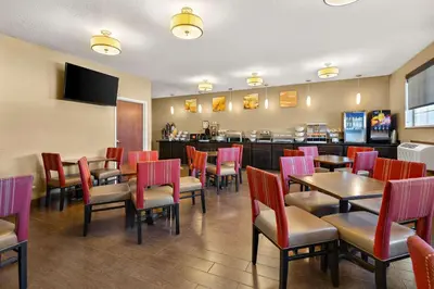 a restaurant with tables and chairs and a bar at Comfort Inn Near Ouabache State Park in Bluffton