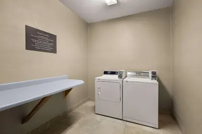 a laundry room with a washing machine and a counter at Comfort Inn Near Ouabache State Park in Bluffton